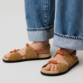Model wearing Claude Pierlot brown suede sandals with orange rope detailing and black sole, styled with cropped wide-leg jeans