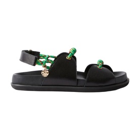 Black flat sandal with green rope strap detail, gold charm embellishment, ankle buckle strap, and chunky black sole