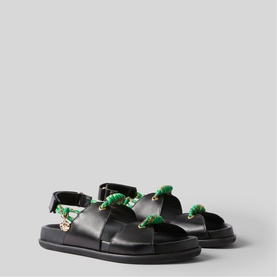 Black leather sandals with green rope detailing and gold chain embellishments, adjustable ankle strap, on a chunky black sole