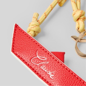 Close-up of red leather Clairsh branded strap with embroidered logo, yellow rope detail, and gold-tone hardware clasp