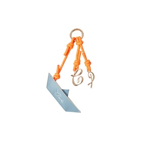 Light blue leather tag charm with orange knotted cord and gold-tone cursive initial pendant, attached to a gold ring