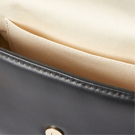 Dark grey leather clutch bag interior showing cream fabric lining and gold-tone press-stud fastening detail