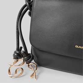 Black leather bucket bag with gold-tone logo charm and drawstring detail, partial close-up view