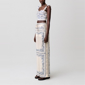 Model wearing cream and blue floral printed wide-leg trousers with matching crop top, styled with dark sandals