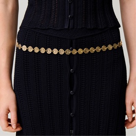 Model wearing Claude Pierlot metallic gold coin disc chain belt styled with navy blue ribbed knit midi skirt and matching top.