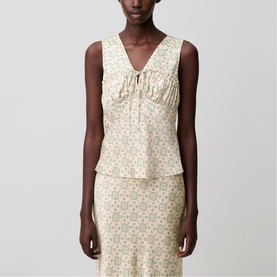 Model wearing cream floral print sleeveless top with ruched V-neckline, styled with matching midi skirt