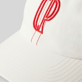 White baseball cap with oversized red embroidered LP monogram logo detail, close-up view of structured brim and crown
