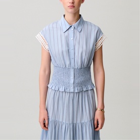 Model wearing Claude Pierlot light blue striped shirt dress with smocked waist, lace trim sleeves, and tiered skirt