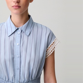 Model wearing Claude Pierlot sleeveless striped shirt dress with button placket, point collar, and crochet lace trim sleeve detail