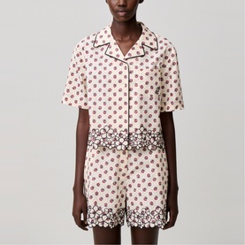 Model wearing cream floral print short-sleeve shirt with dark contrast trim and matching shorts set