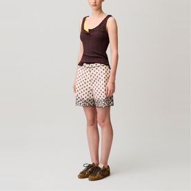 Model wearing Claude Pierlot Womens French Dress in light print polka dot shorts with dark floral border hem, styled with brown tank top and leopard