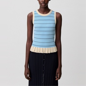 Model wearing Claude Pierlot sleeveless striped knit top in blue and cream with pleated hem, styled with a dark pleated skirt.