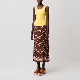 Model wearing brown floral print midi skirt with yellow ribbed tank top and orange block-heel mules