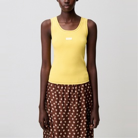 Model wearing yellow ribbed sleeveless tank top with small logo detail, styled with brown floral print skirt