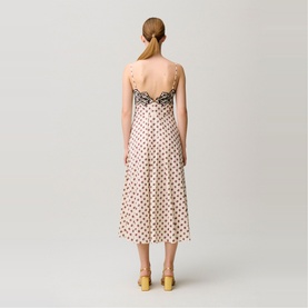 Model wearing cream polka dot midi slip dress with black lace trim back detail, styled with yellow heeled mules