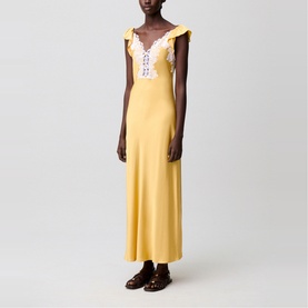 Model wearing yellow maxi slip dress with lace trim neckline and ruffle shoulders, styled with dark brown loafers