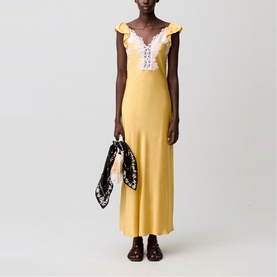 Model wearing yellow maxi slip dress with white lace V-neckline and ruffle straps, styled with dark loafers and printed scarf