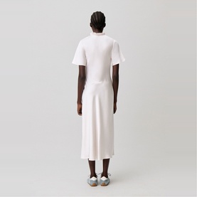 Model wearing Claude Pierlot Womens French Dress in clear white, short sleeves, midi length, seen from behind, styled with silver flat shoes