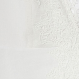 White fabric with delicate tone-on-tone floral lace embroidery detail, shown as a close-up texture shot