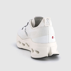 On Running trainer in white, rear three-quarter view showing mesh upper, logo detail, chunky white sole with cutout pods and red flag tab.
