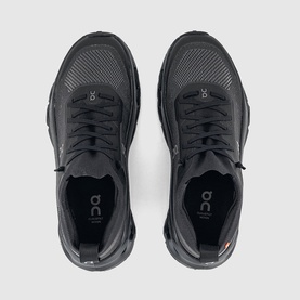 On Running trainers in all-black colourway, overhead flat-lay showing lace-up design, cushioned sole and branded insole
