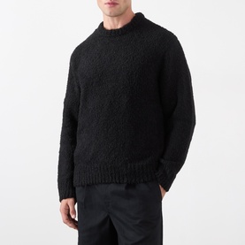 Model wearing Edwin black boucle crew neck knit sweater, styled with dark trousers