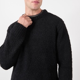 Model wearing Edwin Black Crew Neck knit jumper in textured boucle fabric, close-up detail shot showing neckline finish.