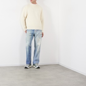 Model wearing Edwin Crew Neck in off white, styled with light wash distressed jeans and grey trainers.