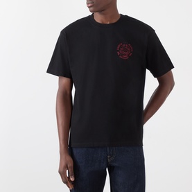 Model wearing Edwin black crew neck T-shirt with red circular chest logo graphic, styled with dark indigo jeans.