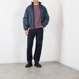 Model wearing Edwin 3049 Loose Jeans in blue rinsed, styled with a teal puffer jacket, mauve sweatshirt and black chunky shoes.