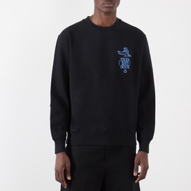 Model wearing Edwin black cotton sweatshirt with small blue graphic print on chest, crew neck, and ribbed cuffs