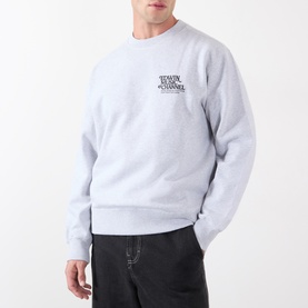 Model wearing Edwin grey marl cotton sweatshirt with small chest logo print, styled with black trousers.