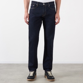 Model wearing Edwin 3049 Tapered Jeans in blue rinsed, styled with dark trainers. Straight-cut leg, classic five-pocket design.
