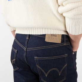 Edwin 3049 tapered jeans in blue rinsed denim, close-up of back pocket with branded leather patch and contrast stitching.