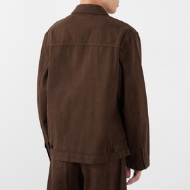 Model wearing Lemaire Flap Pocket Overshirt in brown cotton, back view, with matching brown trousers