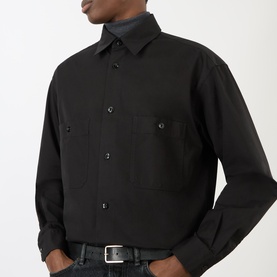 Model wearing Lemaire black cotton casual shirt with chest pockets and button-front placket, styled with dark jeans and silver belt