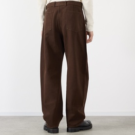 Model wearing Lemaire Belted Casual Trousers in brown, straight-leg fit with tonal stitching, styled with a cream knit and black leather shoes.