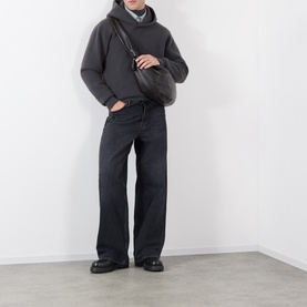 Model wearing Lemaire dark grey cashmere hoodie with black wide-leg jeans, black loafers, and a dark crossbody bag.