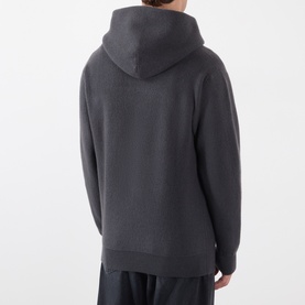 Model wearing Lemaire Dark Grey cashmere hoodie, shown from behind, with matching dark grey trousers.