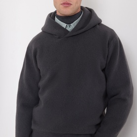 Model wearing Lemaire dark grey cashmere hoodie, styled with a sage green collared shirt underneath.