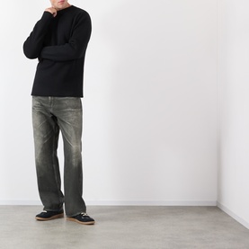Model wearing Lemaire black wool crew neck knit with grey distressed jeans and black loafers.