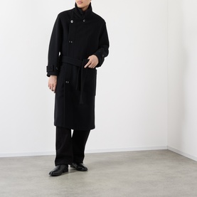 Model wearing Lemaire black wool double-breasted coat, styled with wide-leg black trousers and black leather shoes.