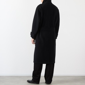 Model wearing Lemaire black wool coat, back view, longline silhouette with belted waist, styled with black trousers
