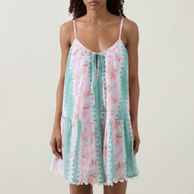 Model wearing Juliet Dunn Loose Scallop Trim Dress in Pistachio/Multi, floral print mini with tiered skirt, tie neckline and scallop hem
