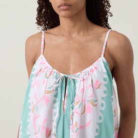 Model wearing Loose Scallop Trim Dress in Pistachio/Multi, showing printed cotton bodice with round neckline, tie detail and thin straps.