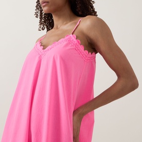 Model wearing Juliet Dunn hot pink cotton slip dress with lace-trim V-neckline and thin shoulder straps, relaxed fit