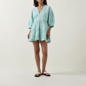 Model wearing Tiered Scalloped Dress in pistachio, V-neckline, tiered cotton skirt with scalloped hem, styled with flat sandals