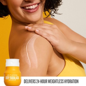 Model with Sol De Janeiro Hydrating Jet Set Cheirosa 62 body cream applied to shoulder, shown alongside yellow product jar.