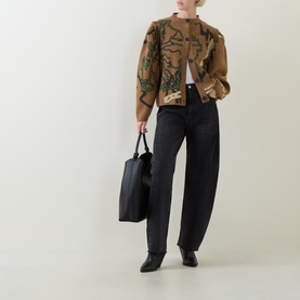 Model wearing Urban Aran brown merino wool cardigan with botanical intarsia design, styled with dark wide-leg jeans and black pointed boots