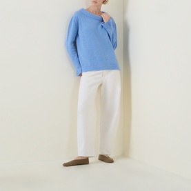 Model wearing Urban Aran blue merino wool knit jumper with white straight-leg trousers and tan loafers